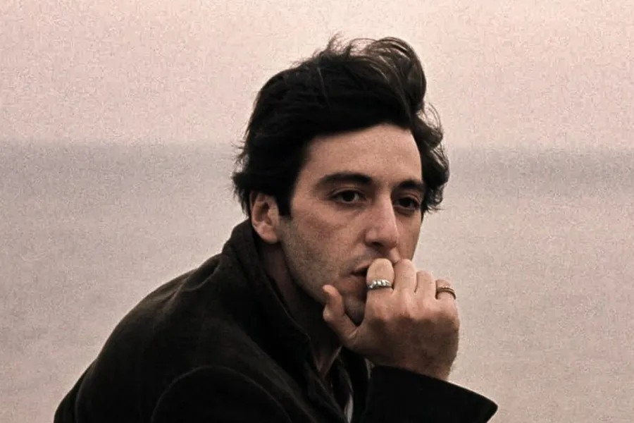Fotograma: el mismo hombre, con la mano junto a la boca, delante de un mar gris.