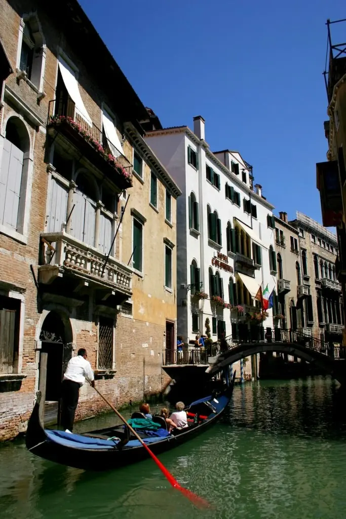 Canal de Venecia: un gondolero rema frente a la fachada del Hotel Colombina.
